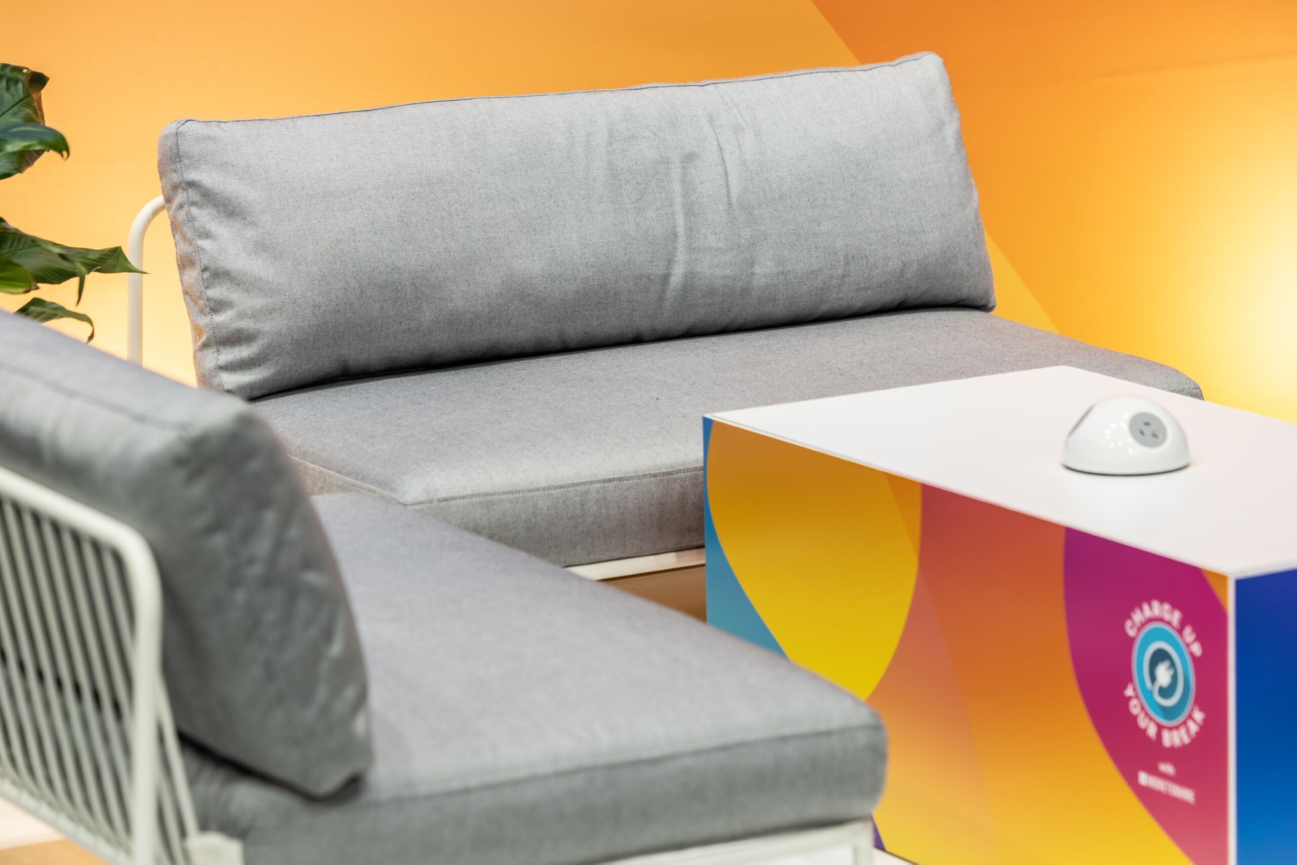 Nolita Lounge with custom grey and off-white fabric, featuring branded signage and Charger Domes for connectivity. By Moreton Hire